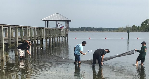 Students from Crescent City Jr./Sr. High School get their feet wet while learning about the lakes of their area.